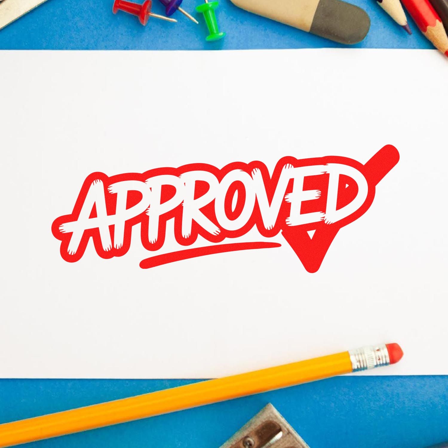 Red Approved rubber stamp on paper with pencils, ideal for office, teacher, or document approval branding.