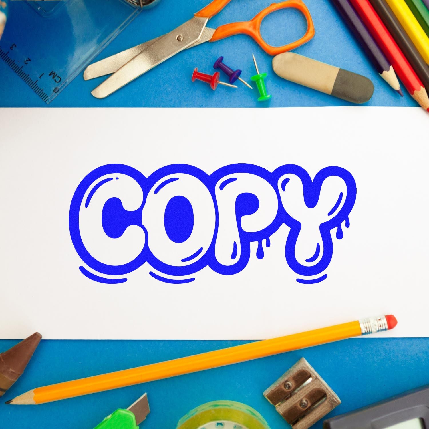 Blue COPY rubber stamp design on white paper, surrounded by school supplies for office, classroom, or duplicate document labeling.