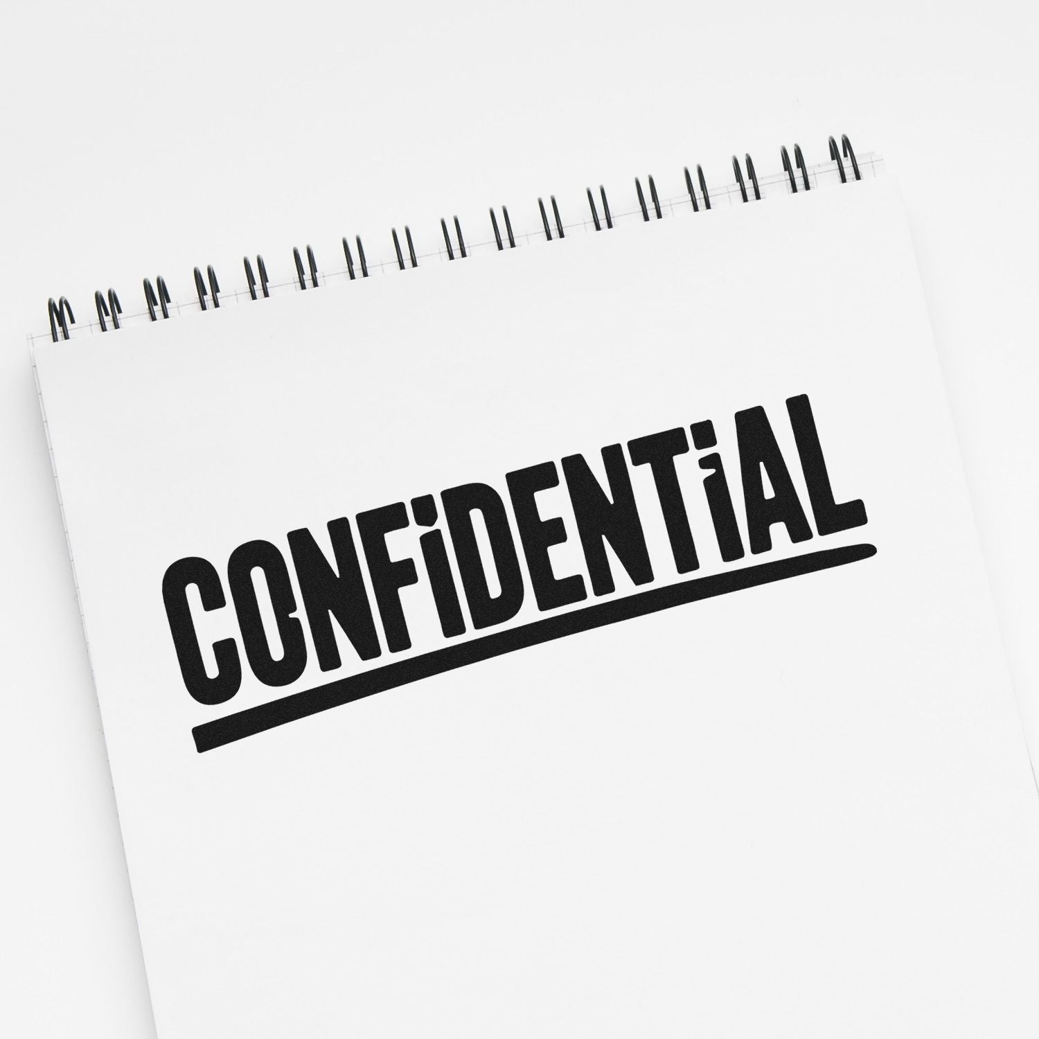 Confidential rubber stamp impression on notebook for secure document marking and private files.
