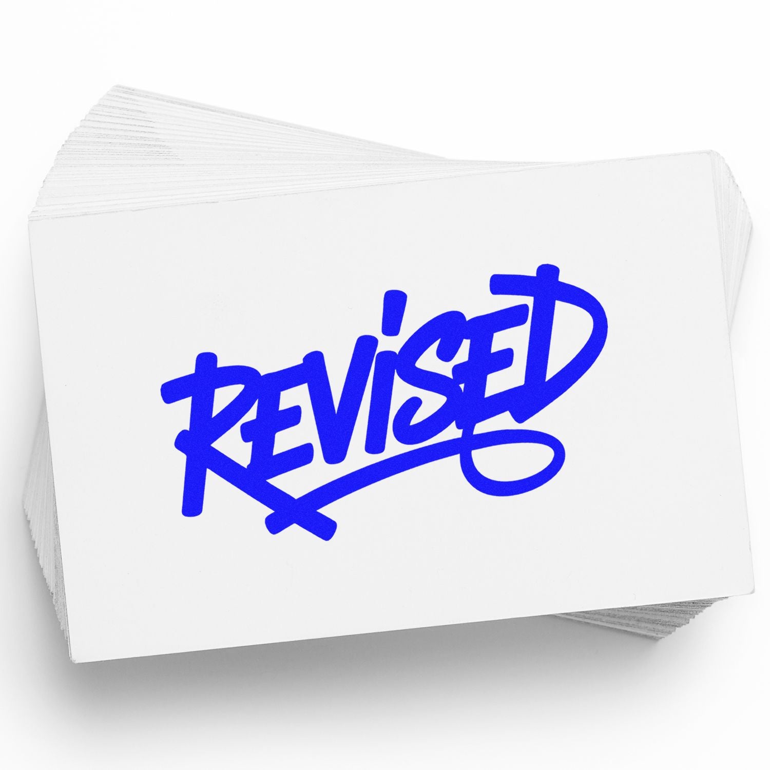 Blue REVISED rubber stamp on stacked white cards for document review, approval, and office records.