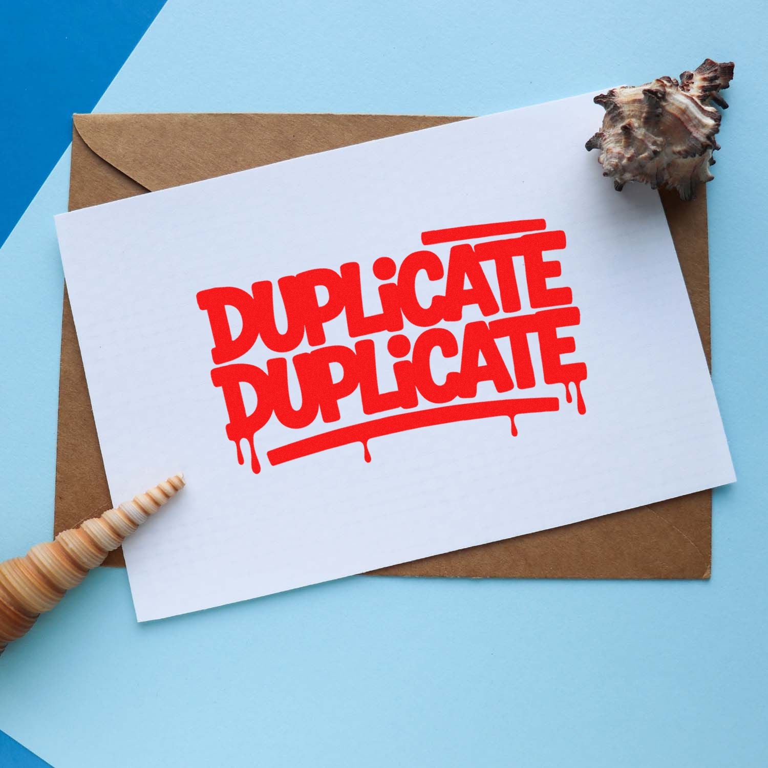 Red Duplicate Duplicate rubber stamp on a white card with envelope, ideal for document marking and mailing.