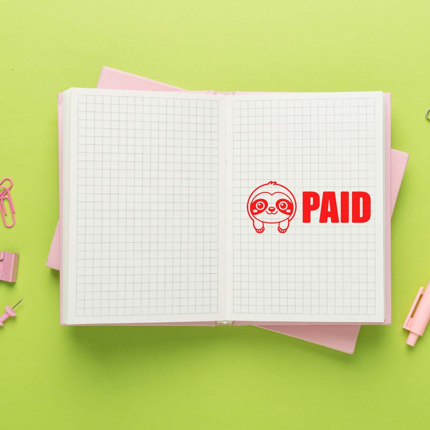 Red PAID rubber stamp on open notebook, ideal for bookkeeping, invoices, and office accounting approval.