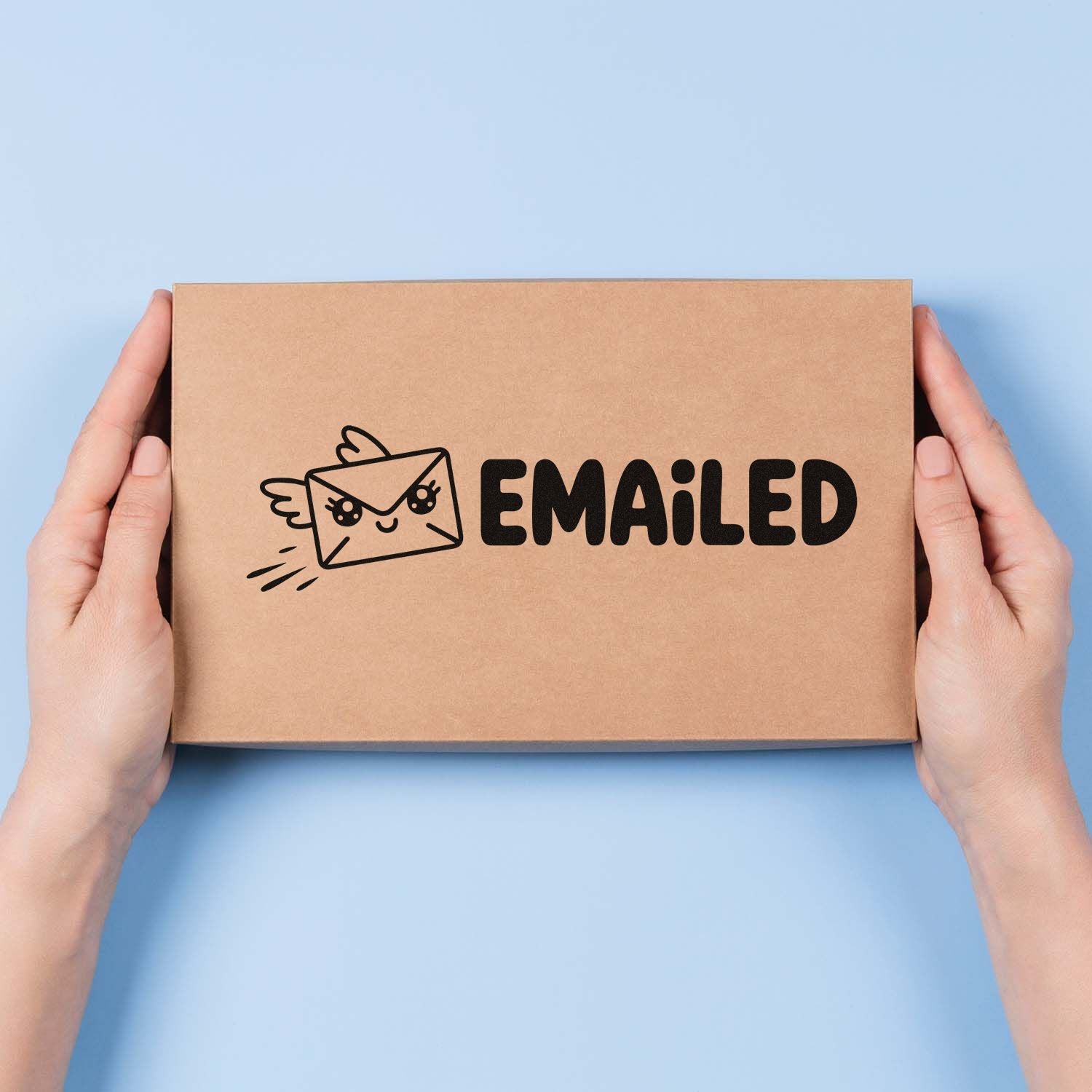 Hands holding a cardboard box with a cute EMAILED rubber stamp design for custom packaging.