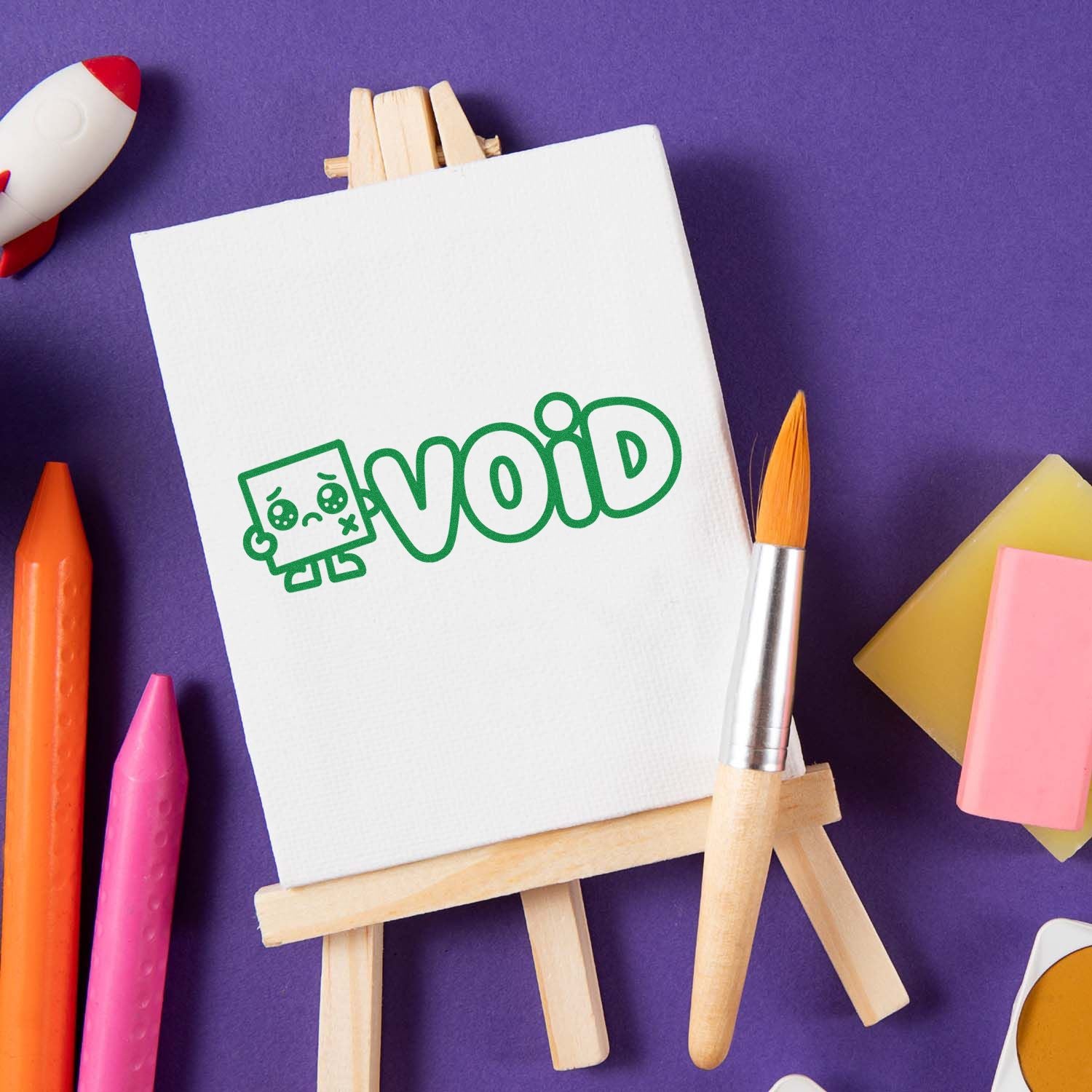 Custom rubber stamp logo mockup with void robot design displayed on an easel with art supplies