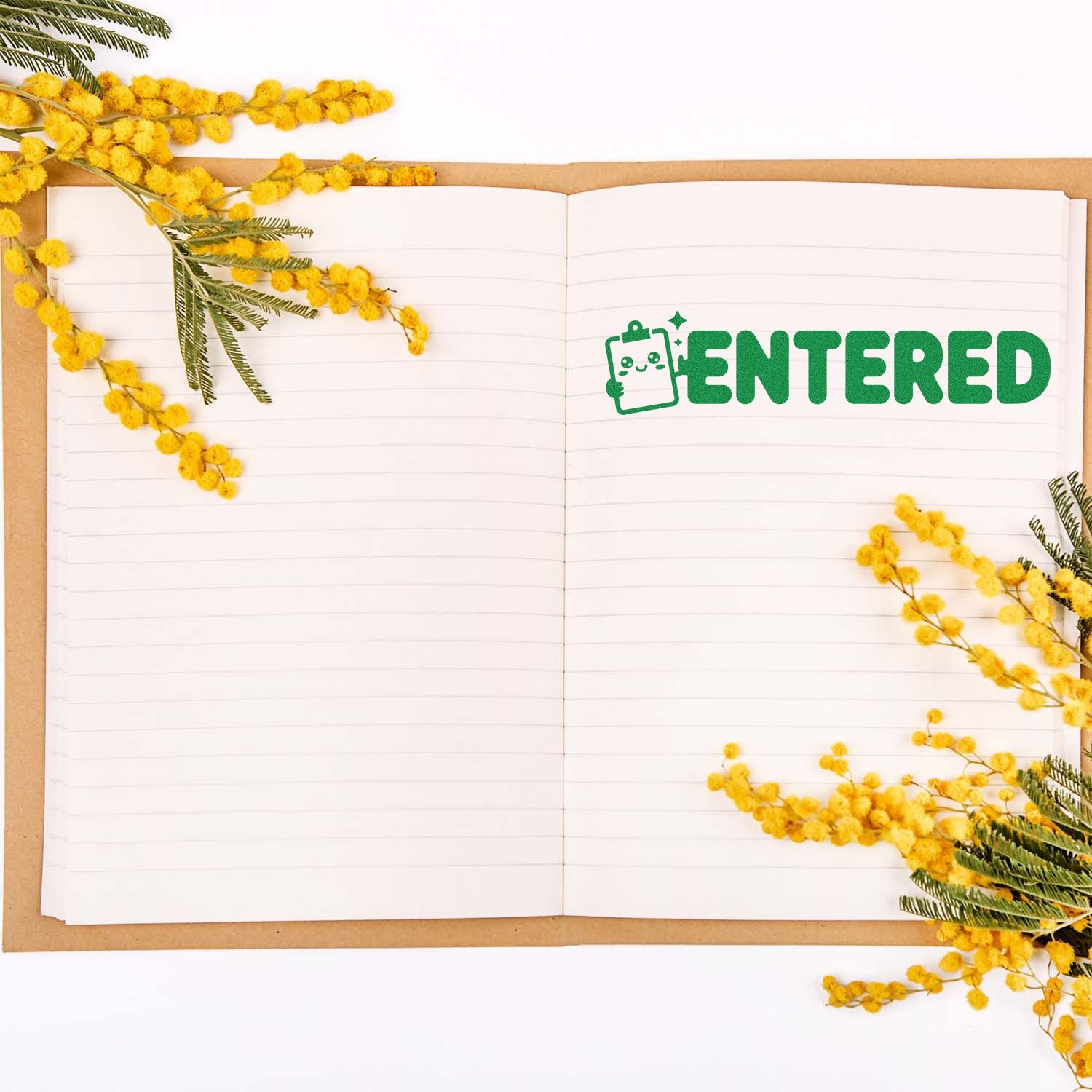 Green ENTERED rubber stamp on open notebook with yellow mimosa flowers
