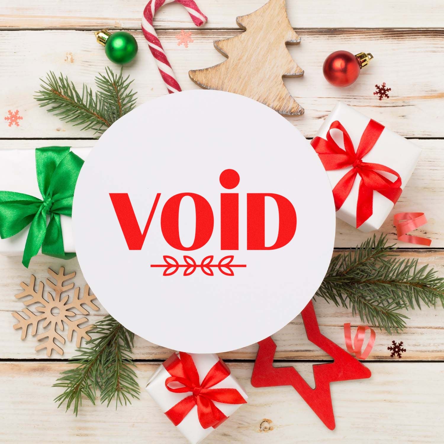 Christmas rubber stamp with red VOID text, holiday gifts, ornaments, and pine branches on a rustic wood background.