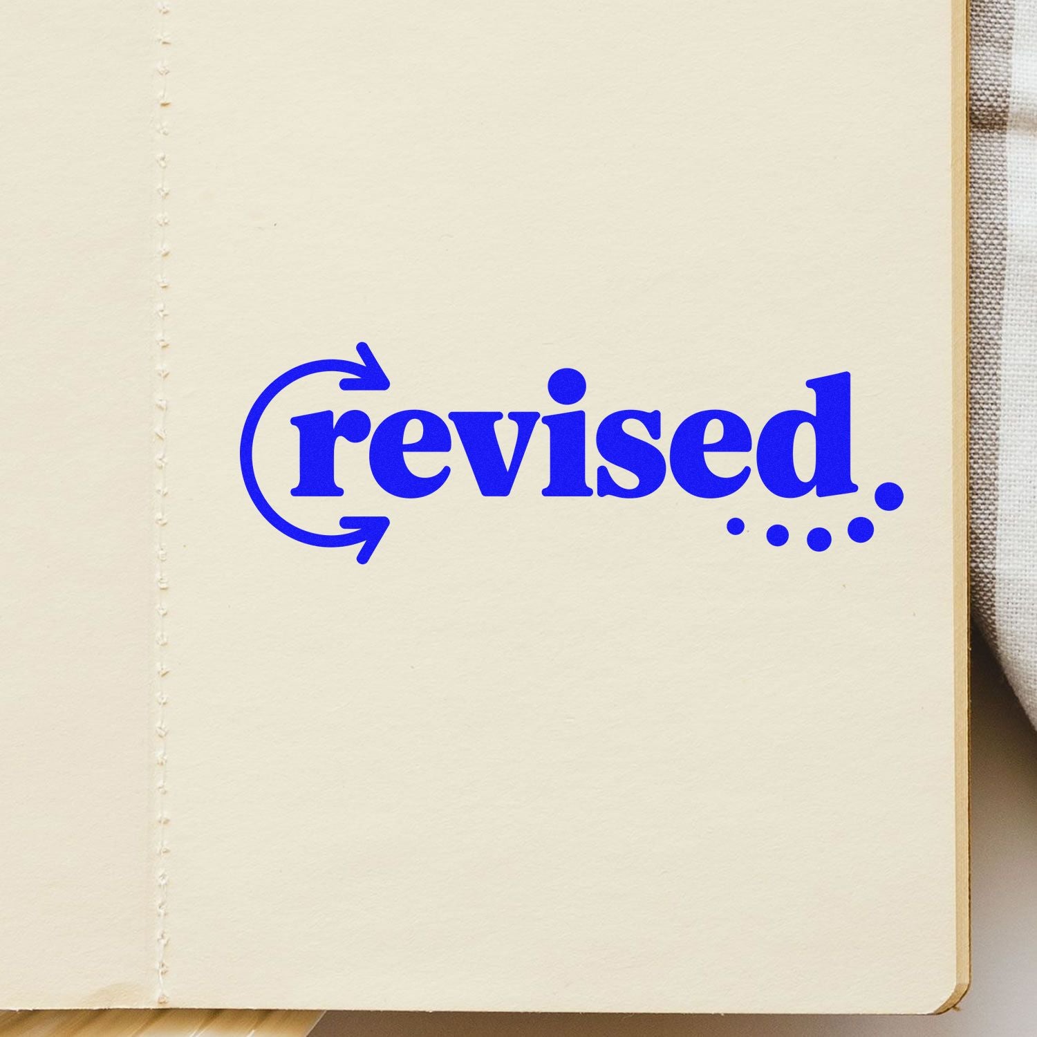 Blue revised rubber stamp on notebook page for marking edited documents and review approvals.