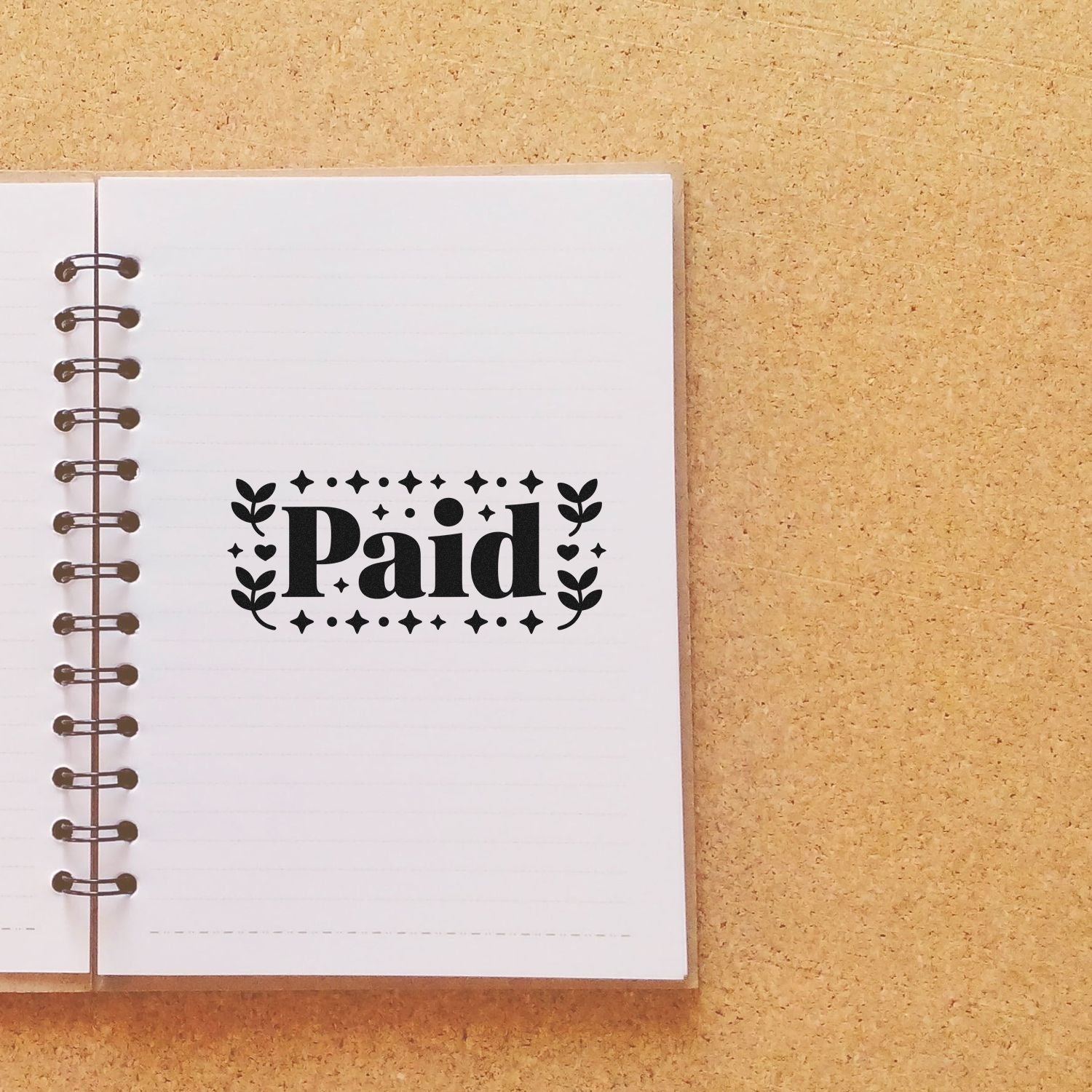 Paid rubber stamp on notebook page for invoices, receipts, and bookkeeping organization.