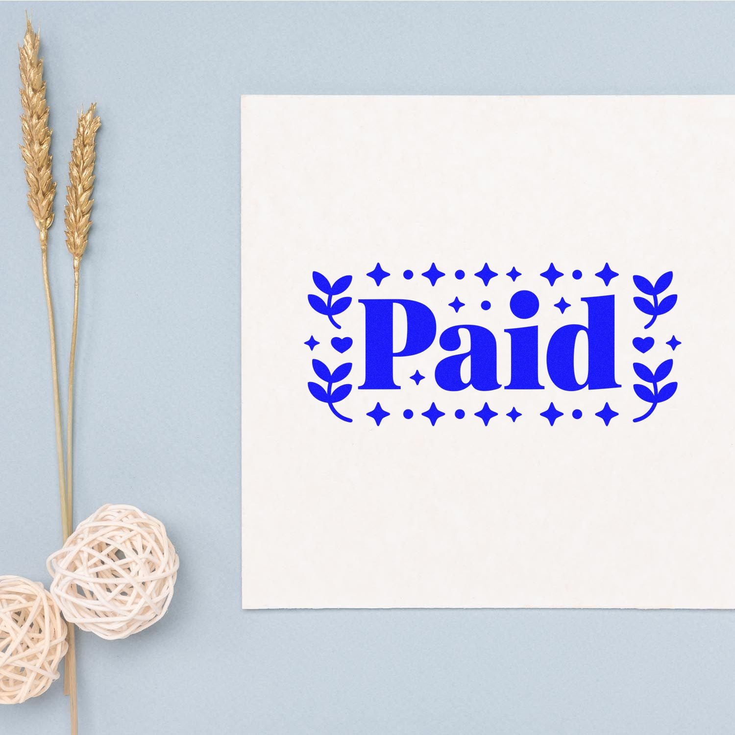 Blue Paid rubber stamp design with decorative stars and leaves on a white card.