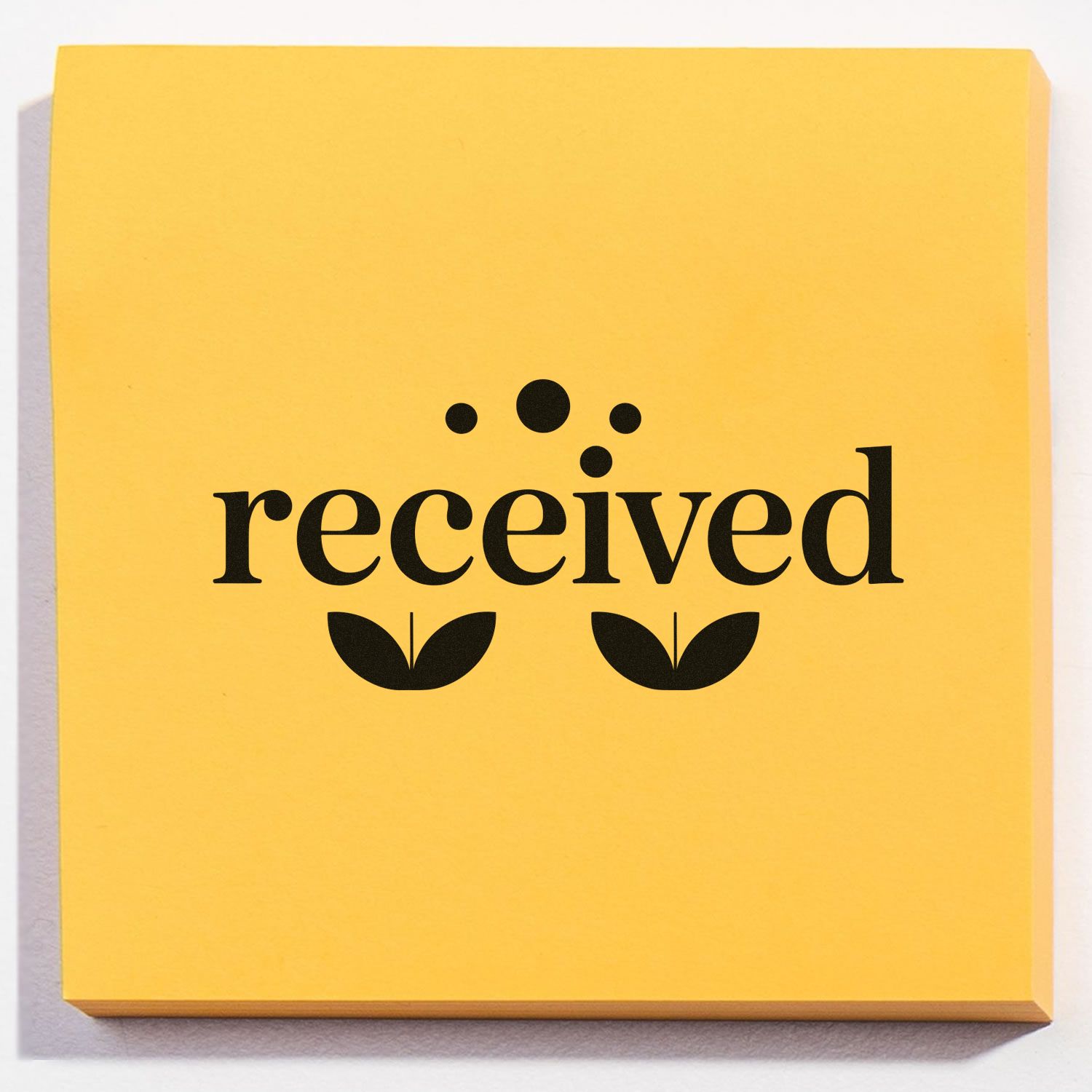 Yellow received rubber stamp with black lettering and floral icon for office mail and approval marking.
