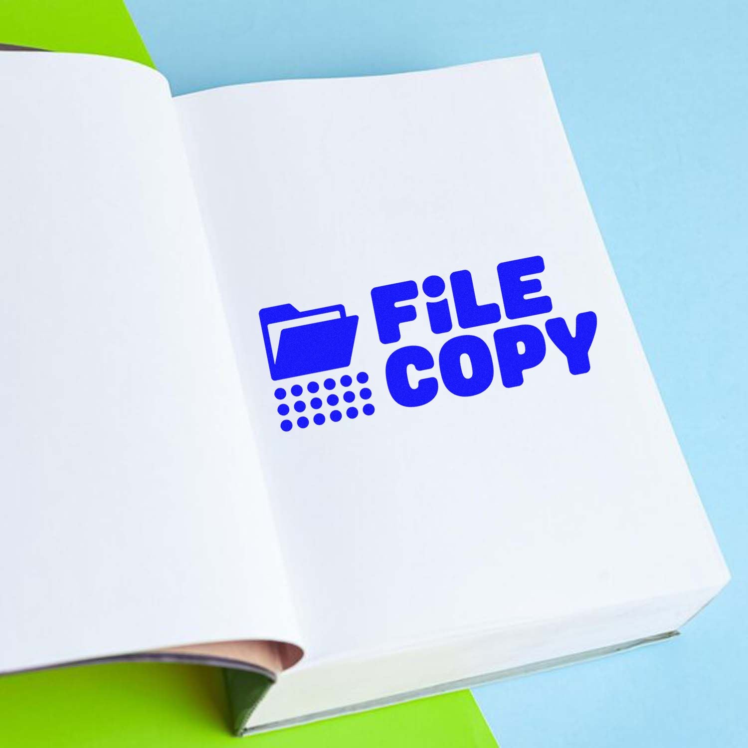 Blue FILE COPY rubber stamp on open notebook for document filing, office records, and duplicate paperwork.