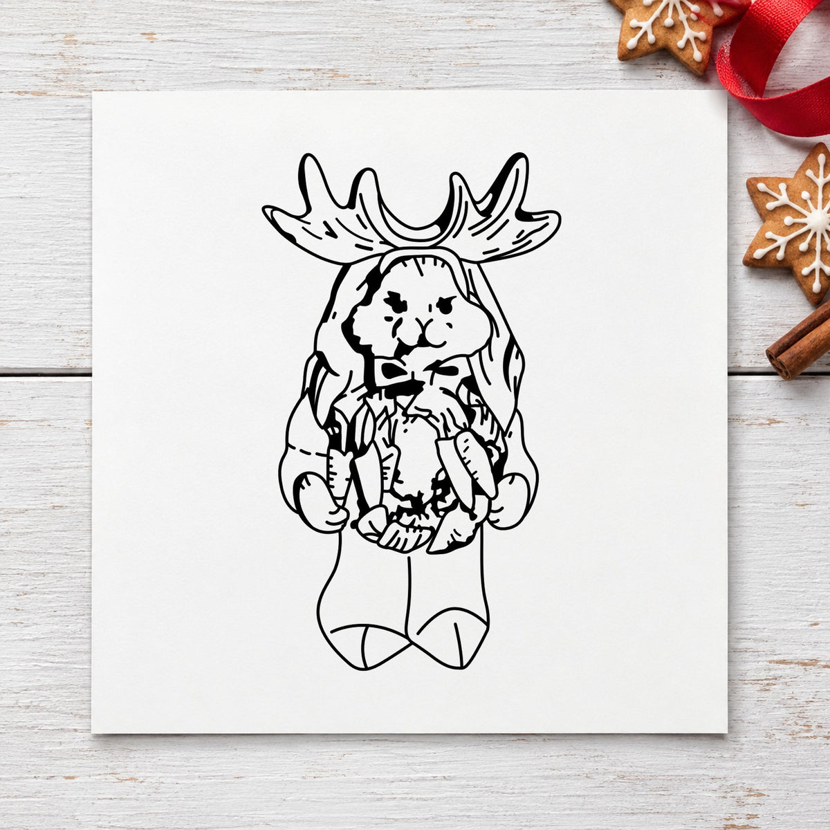 Black impression from a christmas bunny stamp, featuring the bunny in reindeer costume design on white paper.