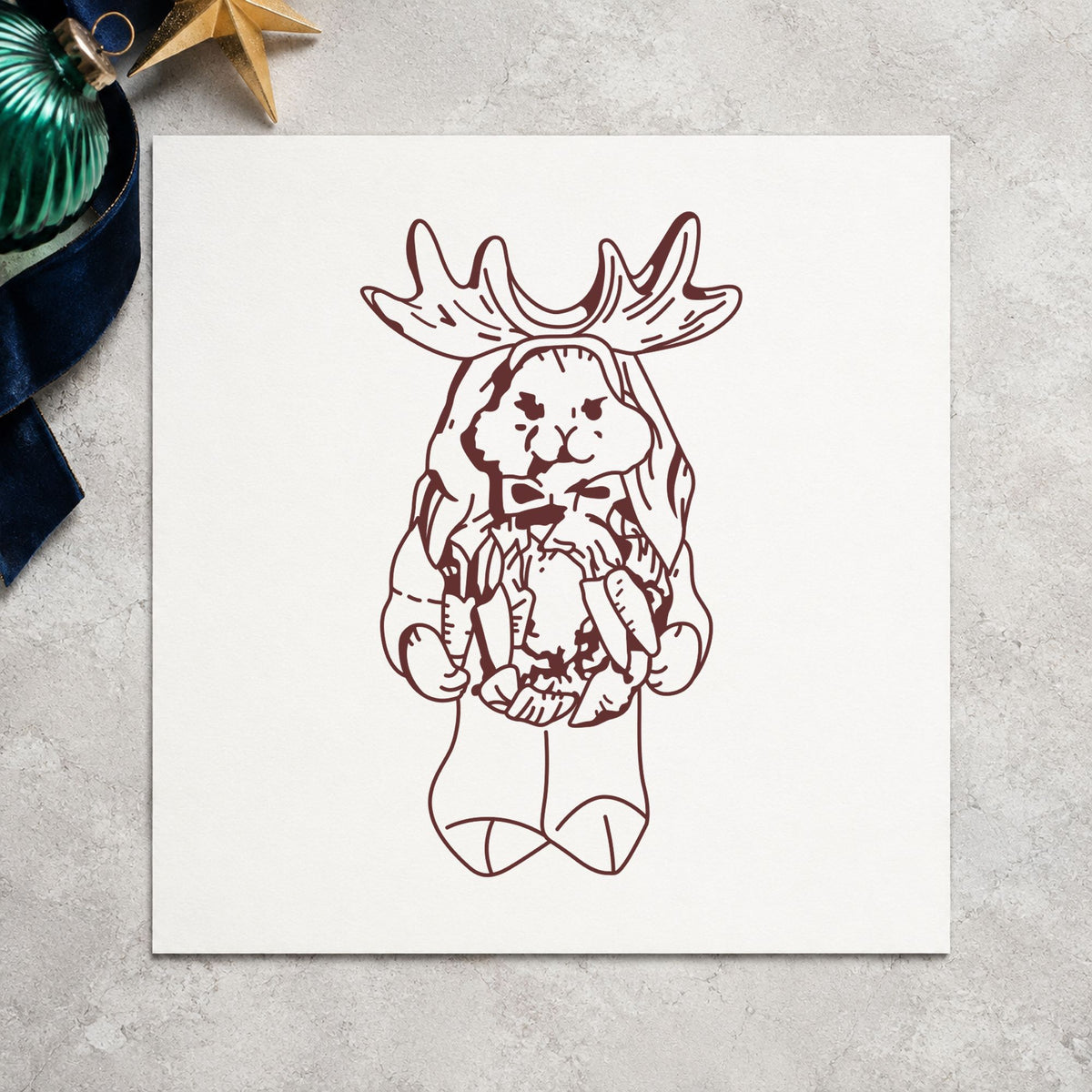 Bunny in Reindeer Costume Rubber Stamp impression in brown ink on white paper in a styled craft setting.