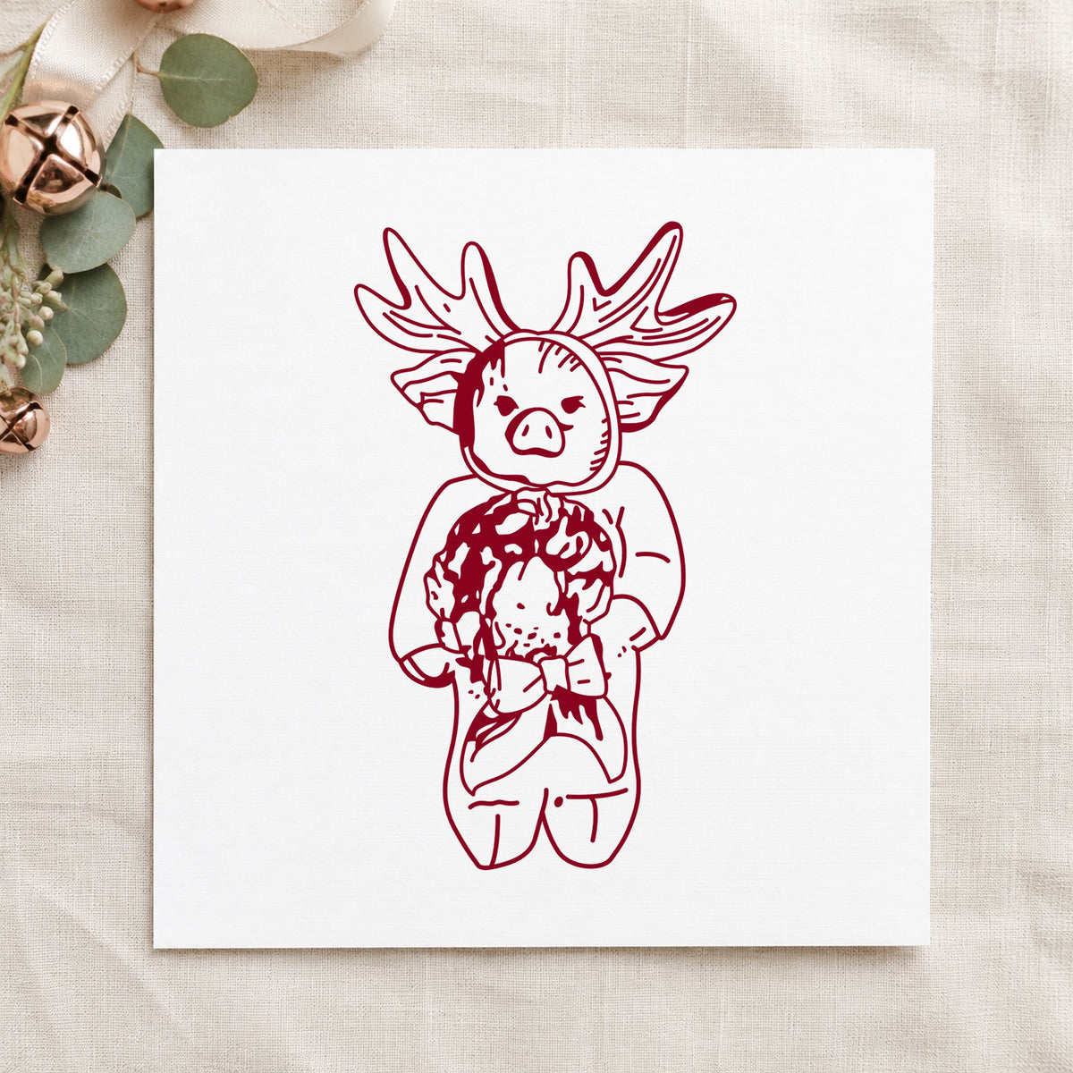 Pig in Reindeer Costume Rubber Stamp impression in burgundy ink on white paper in a styled craft setting.