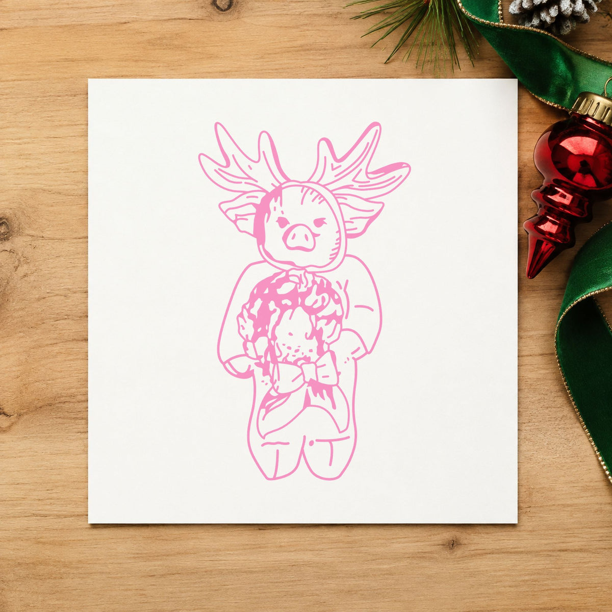 Pig in Reindeer Costume Rubber Stamp impression in pink ink on white paper in a styled craft setting.