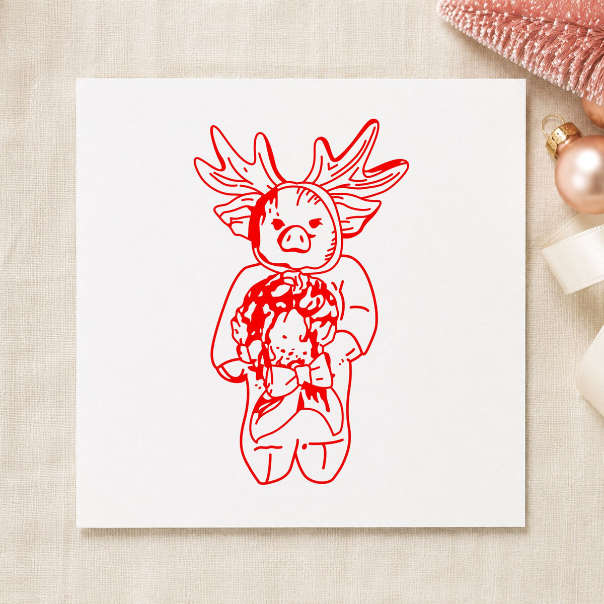 Pig in Reindeer Costume Rubber Stamp impression in red ink on white paper in a styled craft setting.