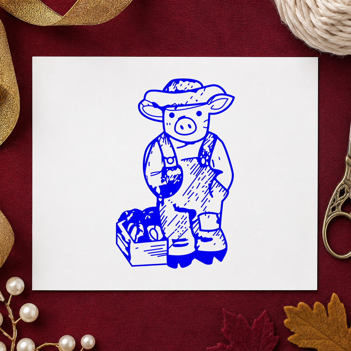 Farmer Pig with Produce Rubber Stamp impression in blue ink on white paper in a styled craft setting.