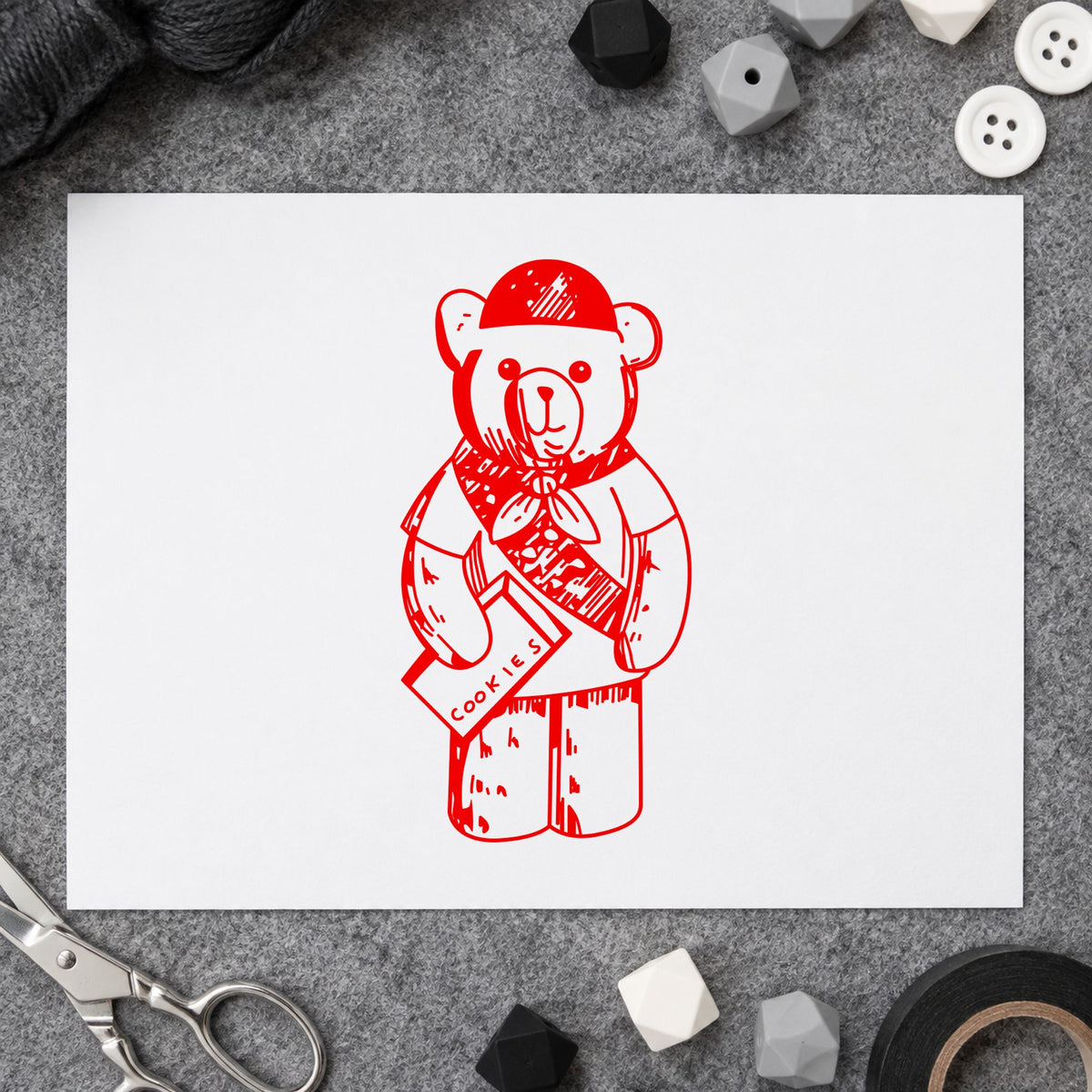 Scout Bear Rubber Stamp impression in red ink on white paper in a styled craft setting.