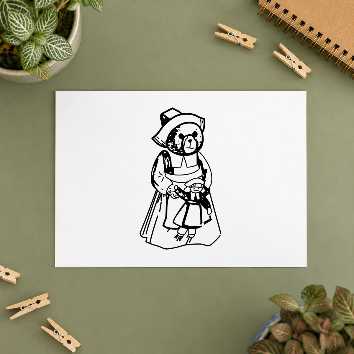 Girl Pilgrim Bear with Doll Rubber Stamp impression in black ink on white paper in a styled craft setting.