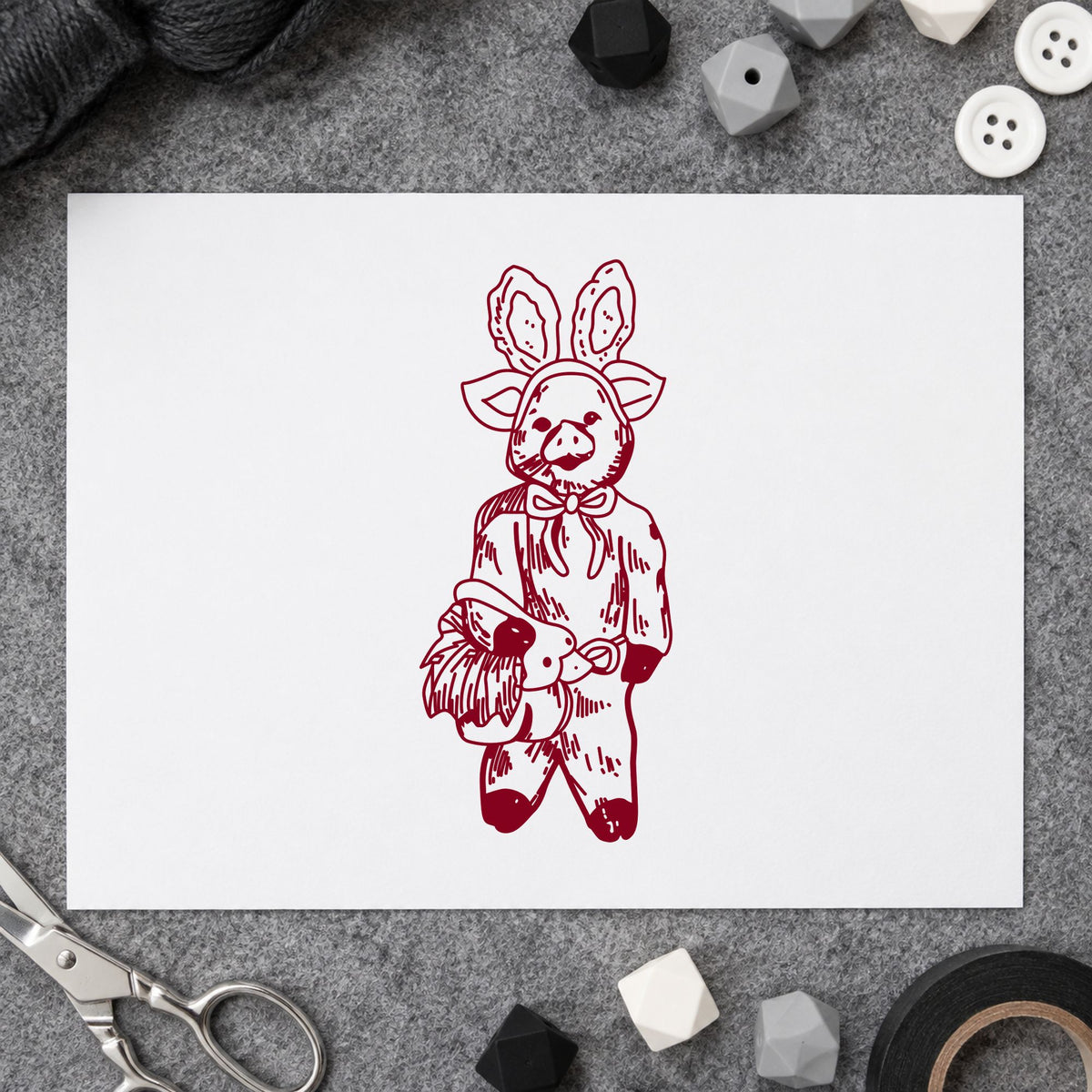 Pig in Bunny Costume with Basket Rubber Stamp impression in burgundy ink on white paper in a styled craft setting.