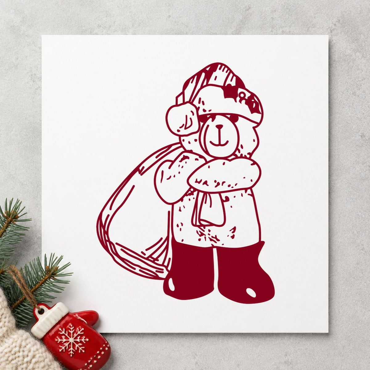Santa Bear with Gift Bag Rubber Stamp impression in burgundy ink on white paper in a styled craft setting.