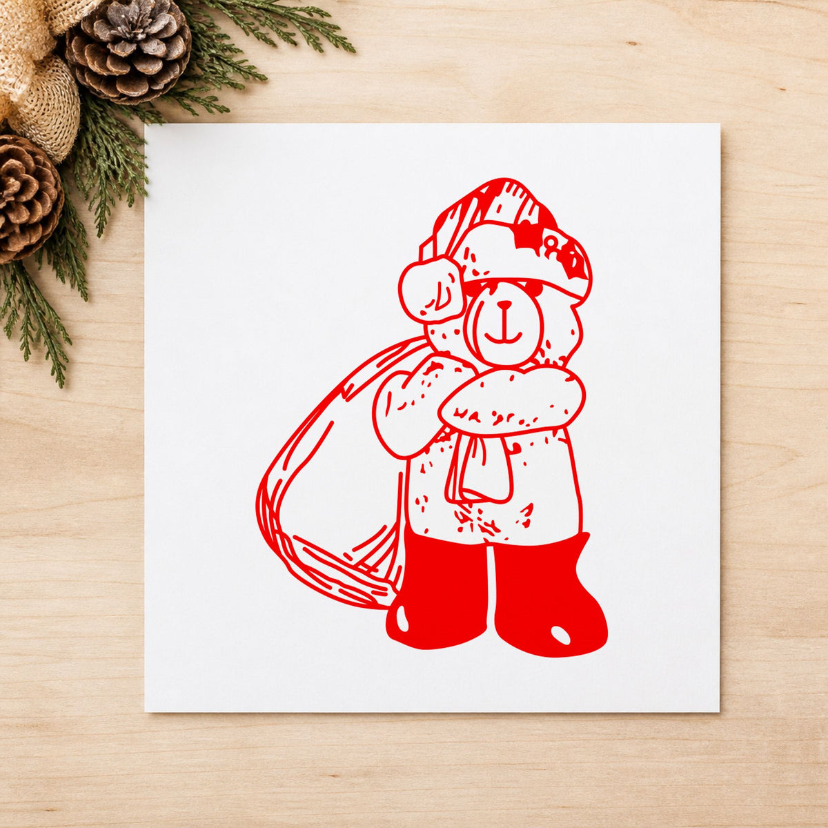 Santa Bear with Gift Bag Rubber Stamp impression in red ink on white paper in a styled craft setting.