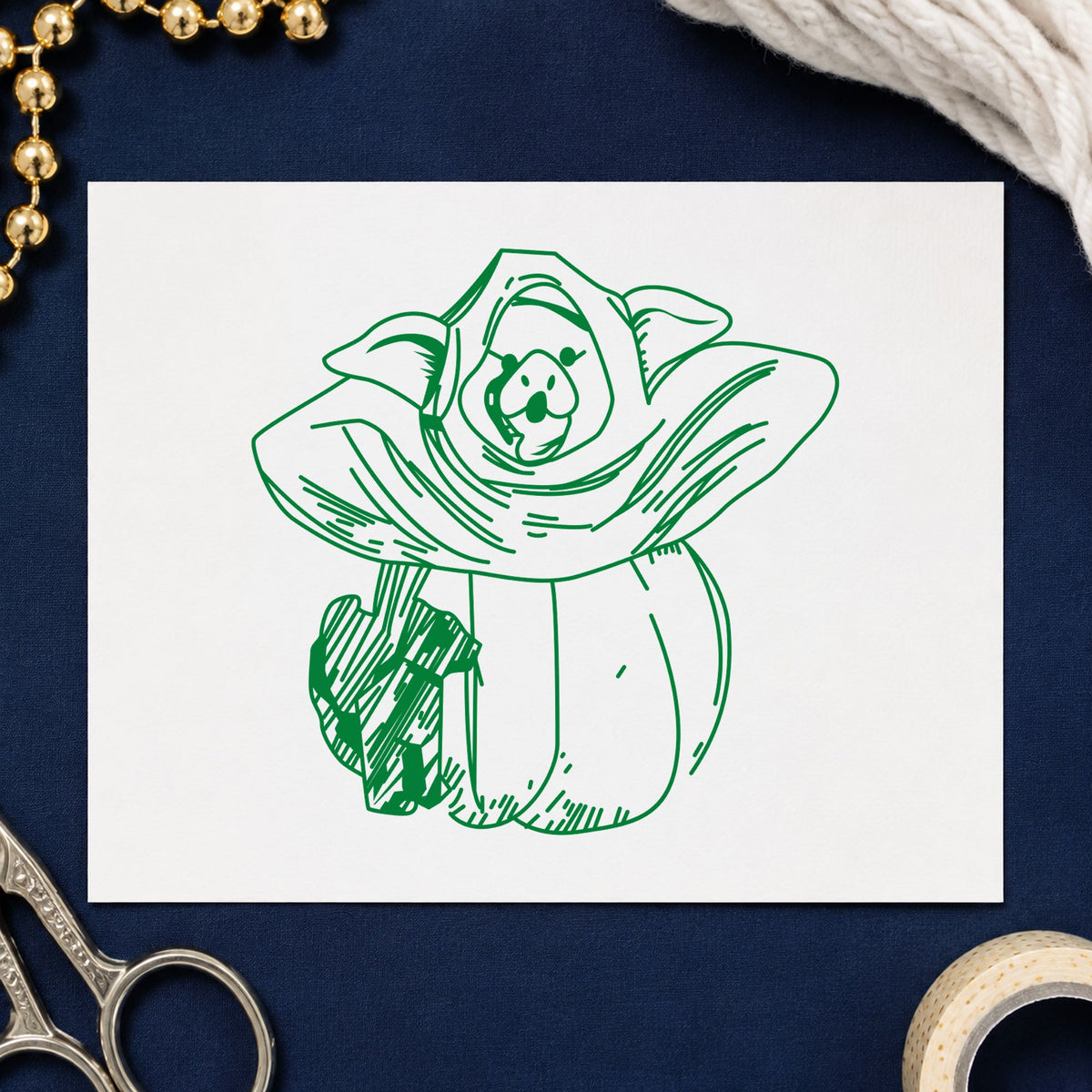 Pumpkin Costume Pig and Black Cat Rubber Stamp impression in green ink on white paper in a styled craft setting.