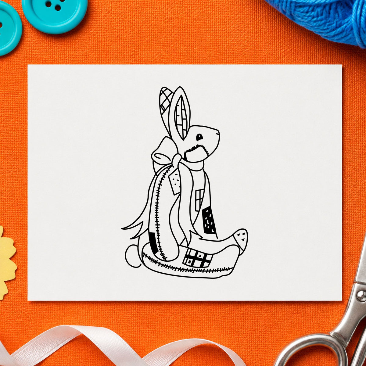 Black impression from a rabbit rubber stamp, featuring the patchwork bunny with bow design on white paper.