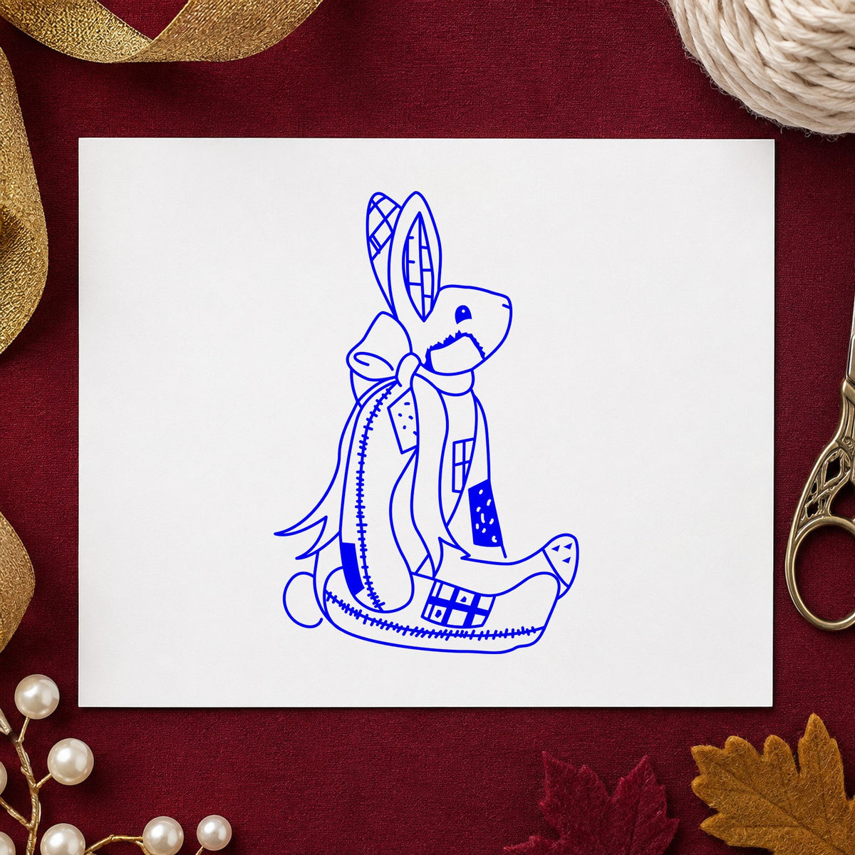 Patchwork Bunny with Bow Rubber Stamp impression in blue ink on white paper in a styled craft setting.