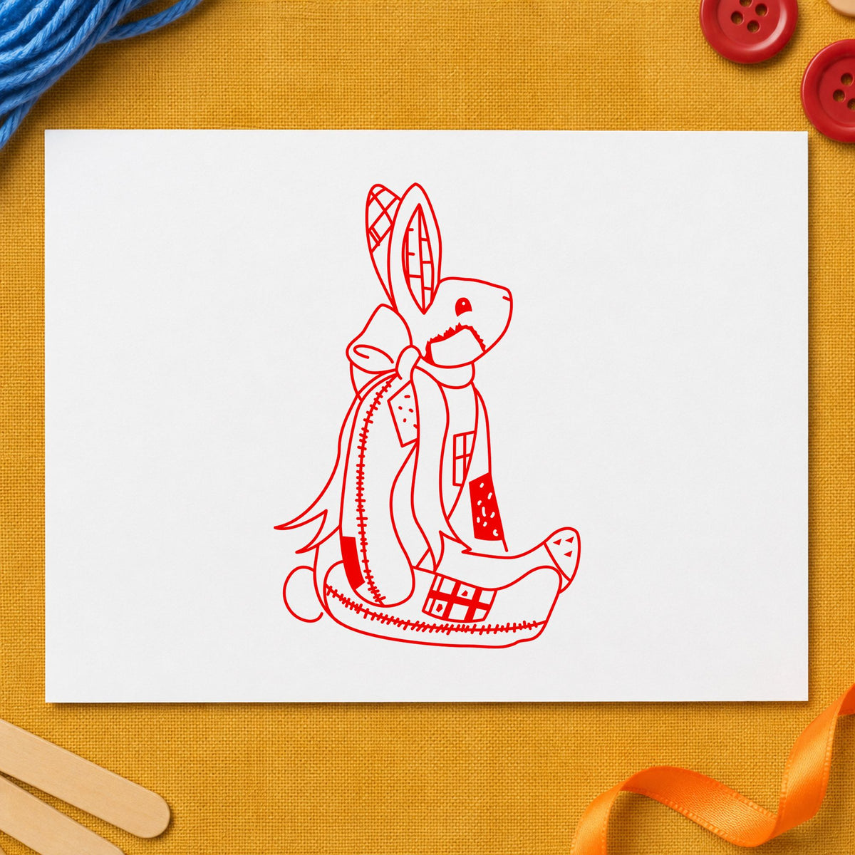 Patchwork Bunny with Bow Rubber Stamp impression in red ink on white paper in a styled craft setting.