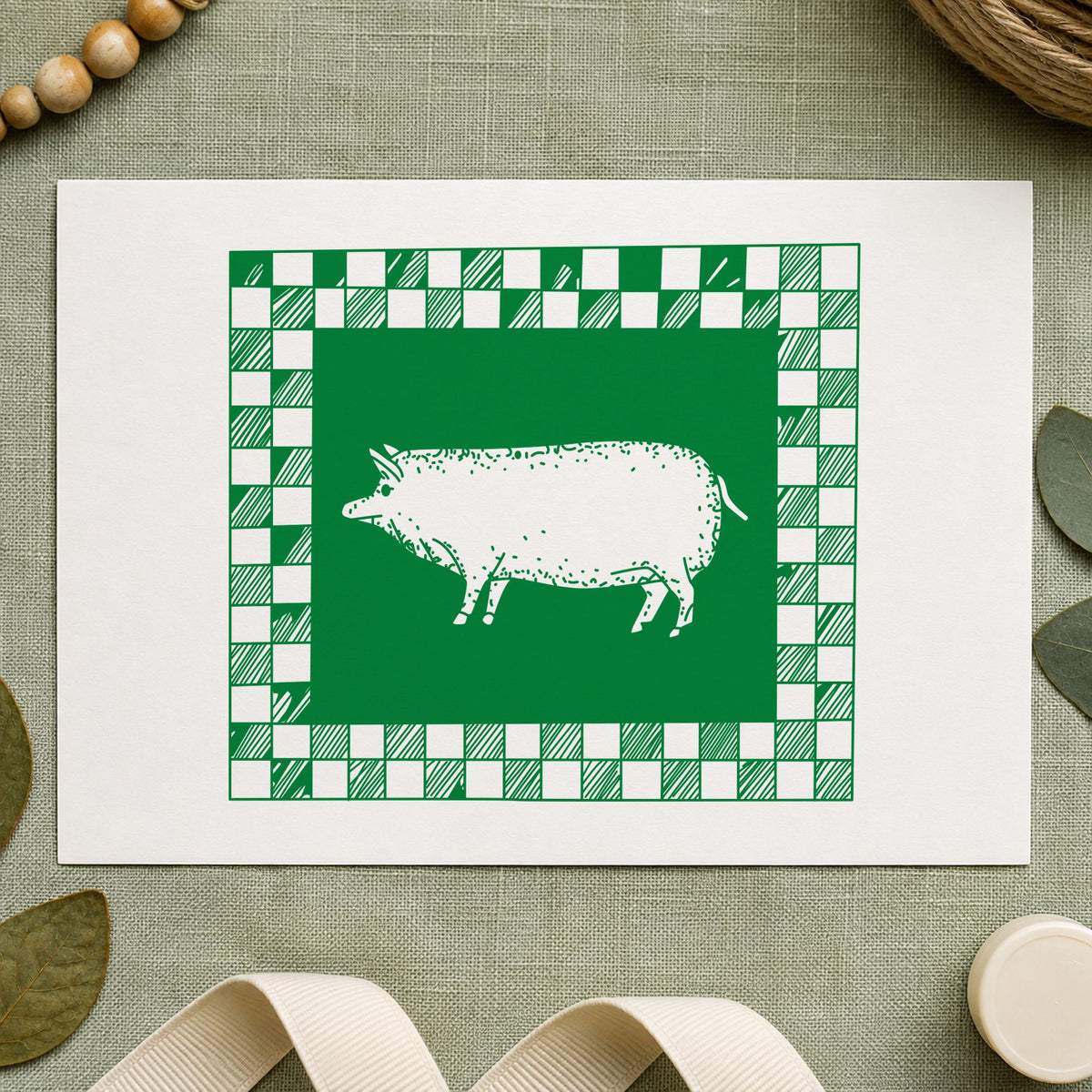 Pig with Checkered Border Rubber Stamp impression in green ink on white paper in a styled craft setting.