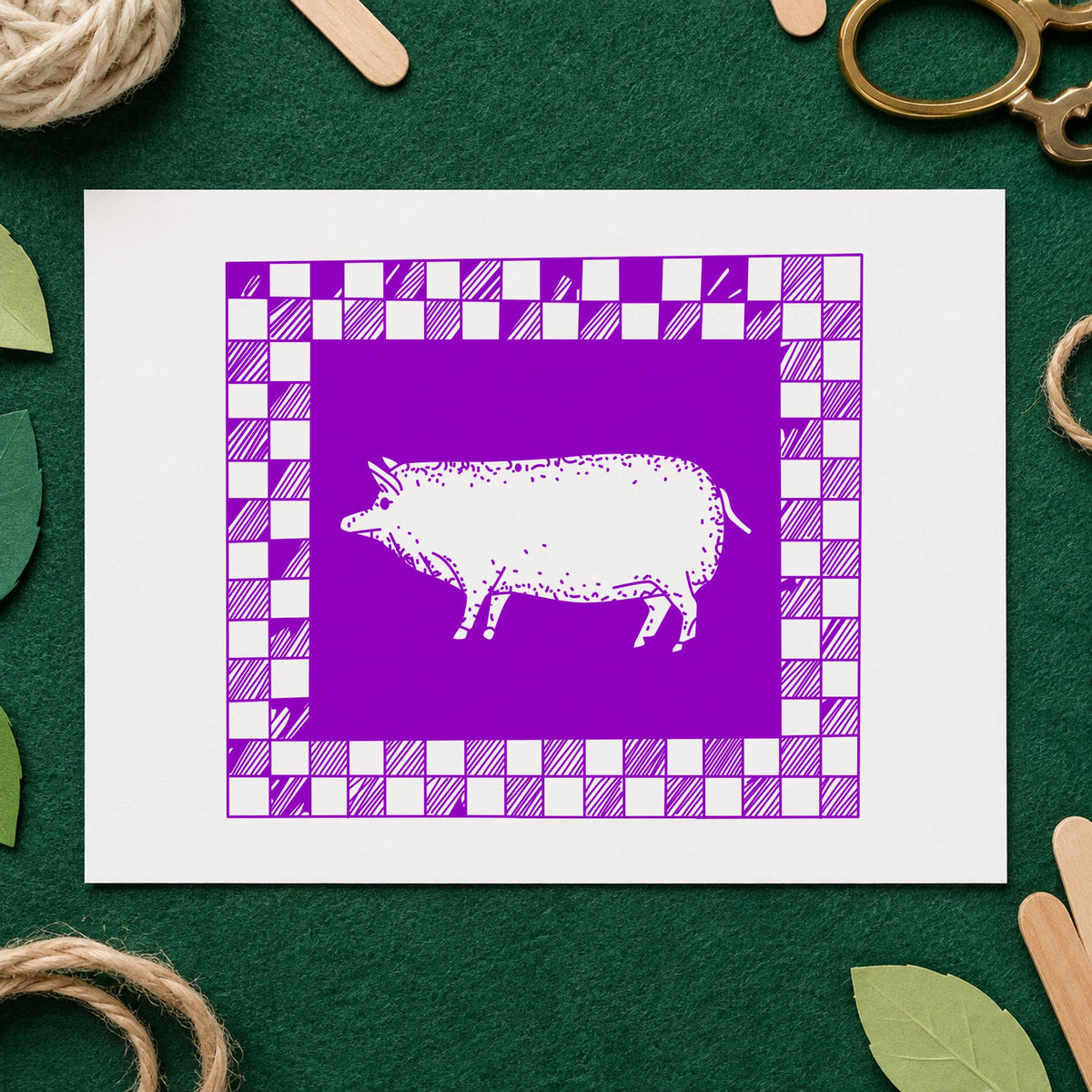 Pig with Checkered Border Rubber Stamp impression in purple ink on white paper in a styled craft setting.