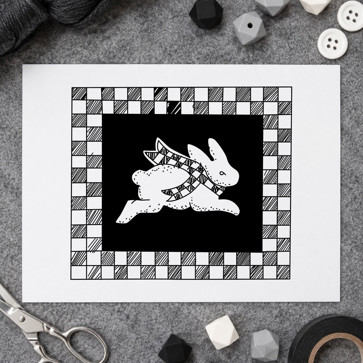 Rabbit with Checkered Border Rubber Stamp impression in black ink on white paper in a styled craft setting.