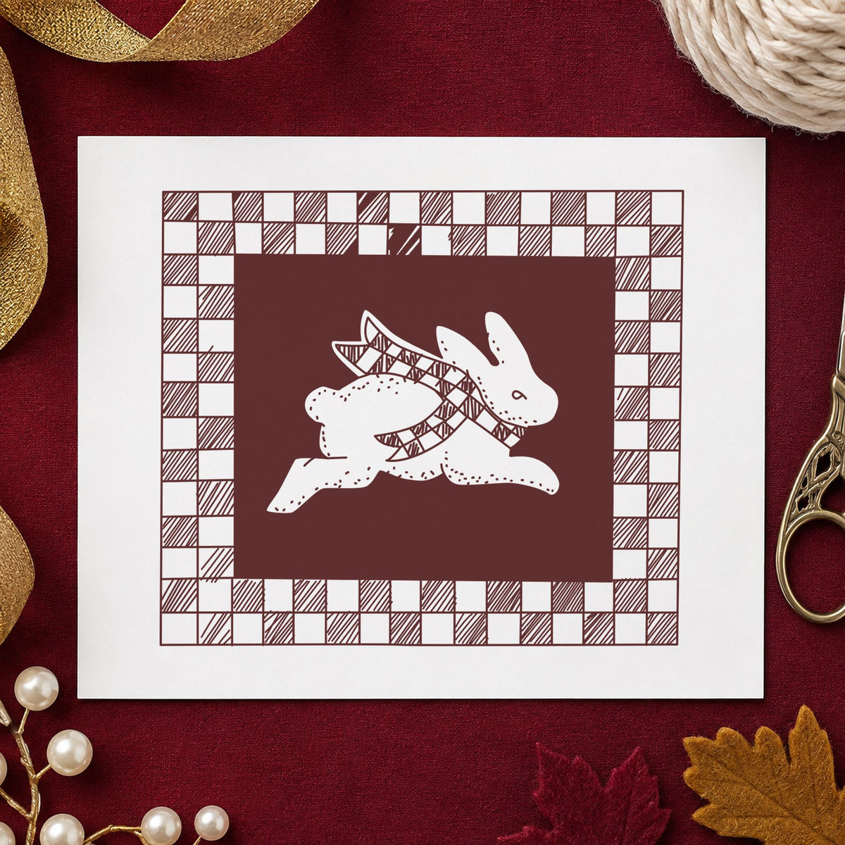 Rabbit with Checkered Border Rubber Stamp impression in brown ink on white paper in a styled craft setting.