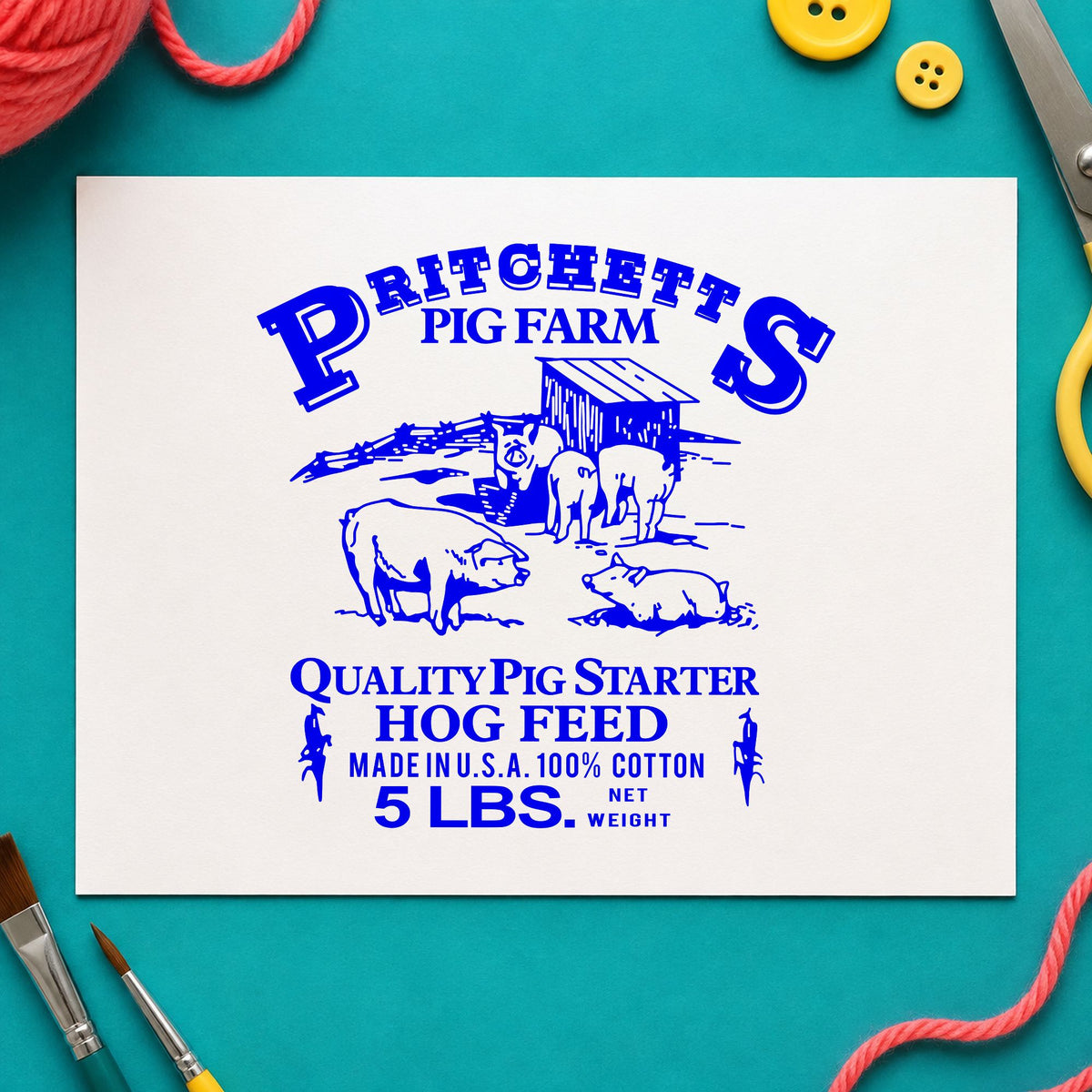 Blue pig rubber stamp impression featuring the hog feed label design on white paper.