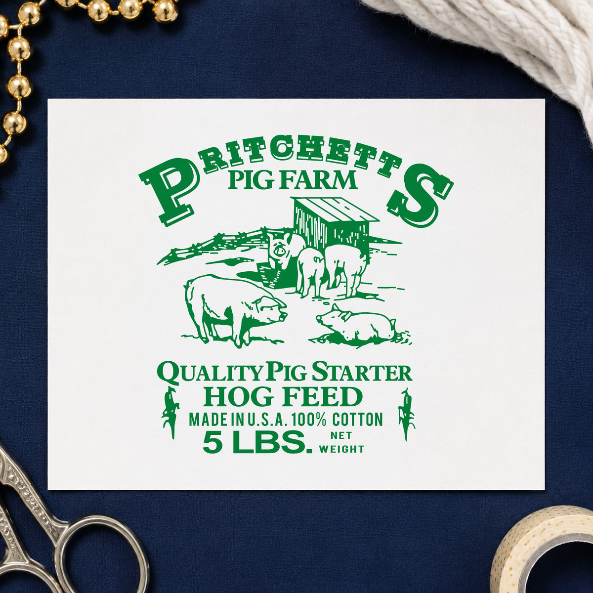 Hog Feed Label Rubber Stamp impression in green ink on white paper in a styled craft setting.