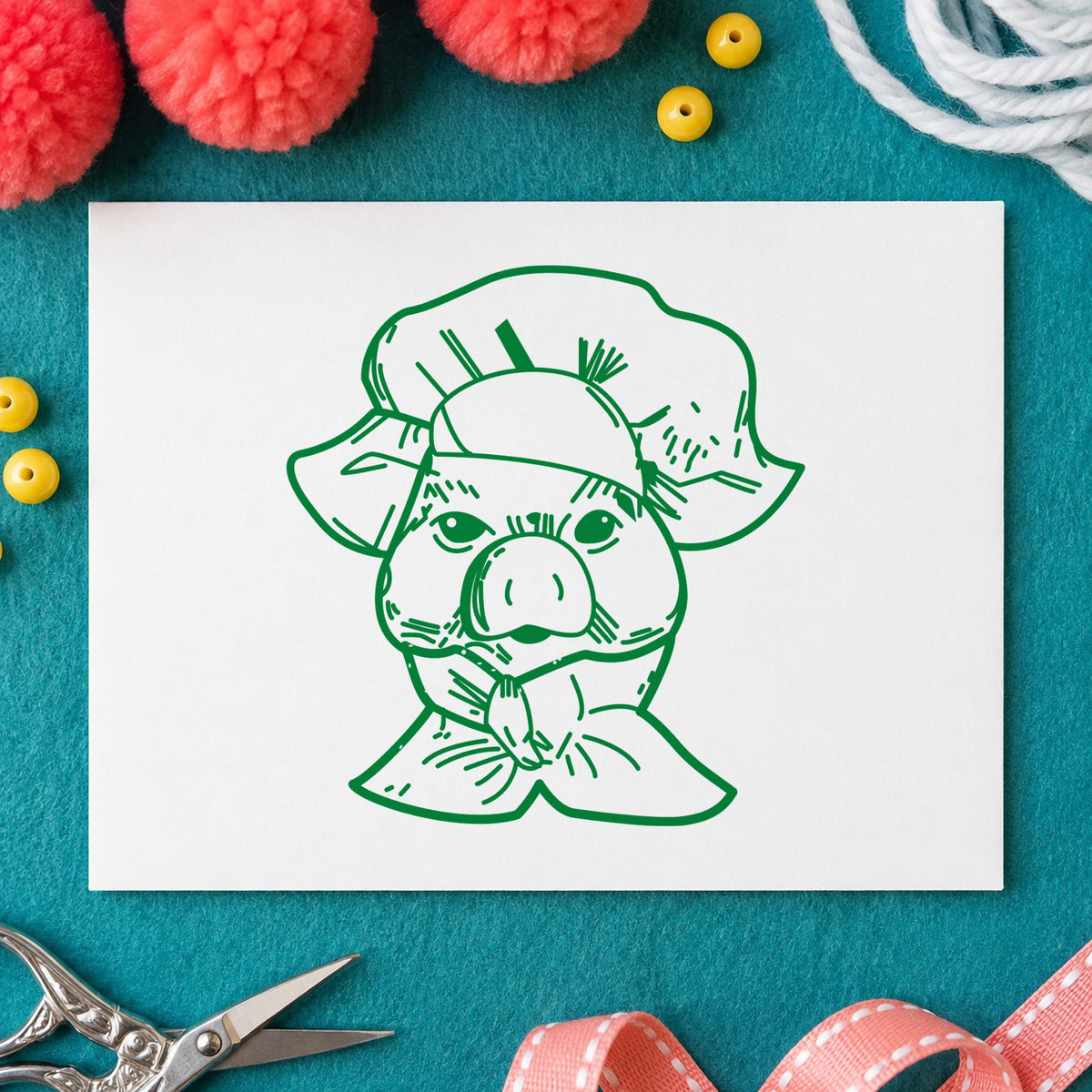 Chef Pig Portrait Rubber Stamp impression in green ink on white paper in a styled craft setting.