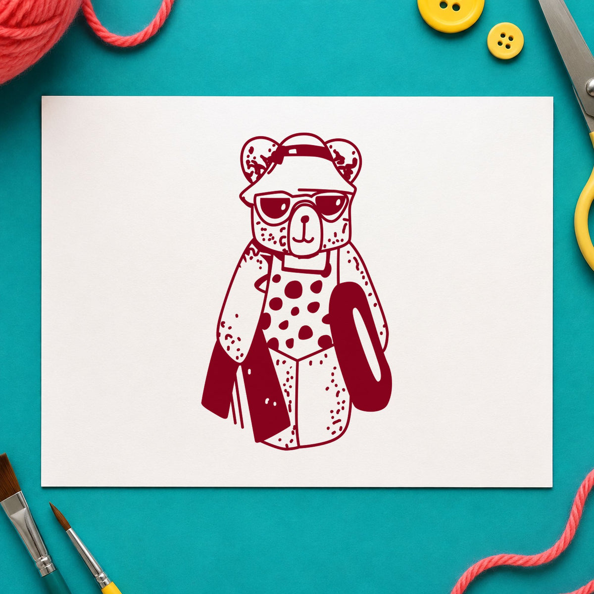 Bear with Inner Tube Rubber Stamp impression in burgundy ink on white paper in a styled craft setting.