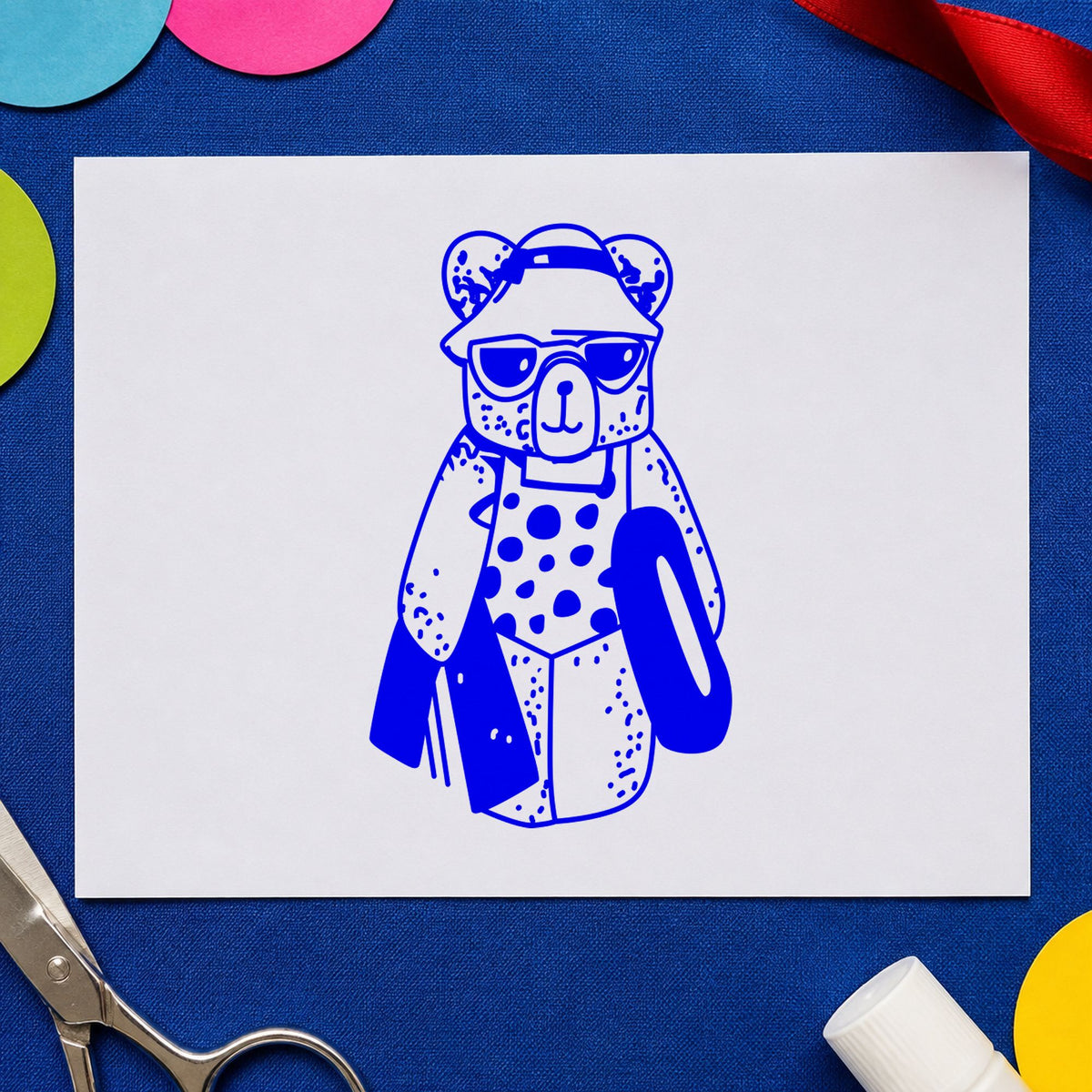 Bear with Inner Tube Rubber Stamp impression in blue ink on white paper in a styled craft setting.