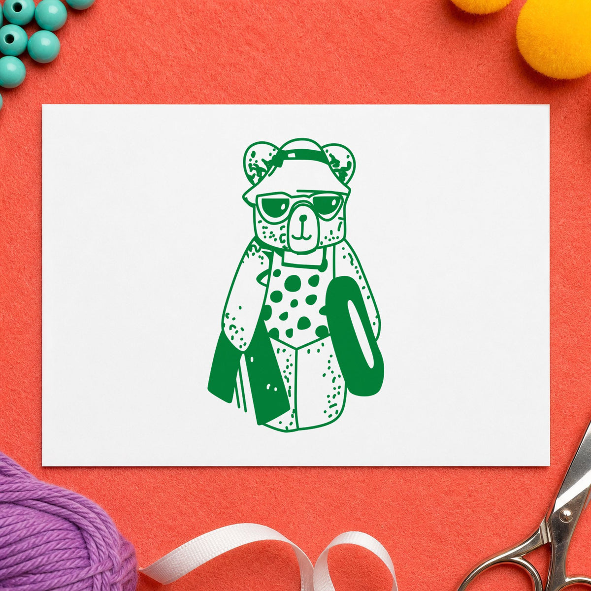 Bear with Inner Tube Rubber Stamp impression in green ink on white paper in a styled craft setting.