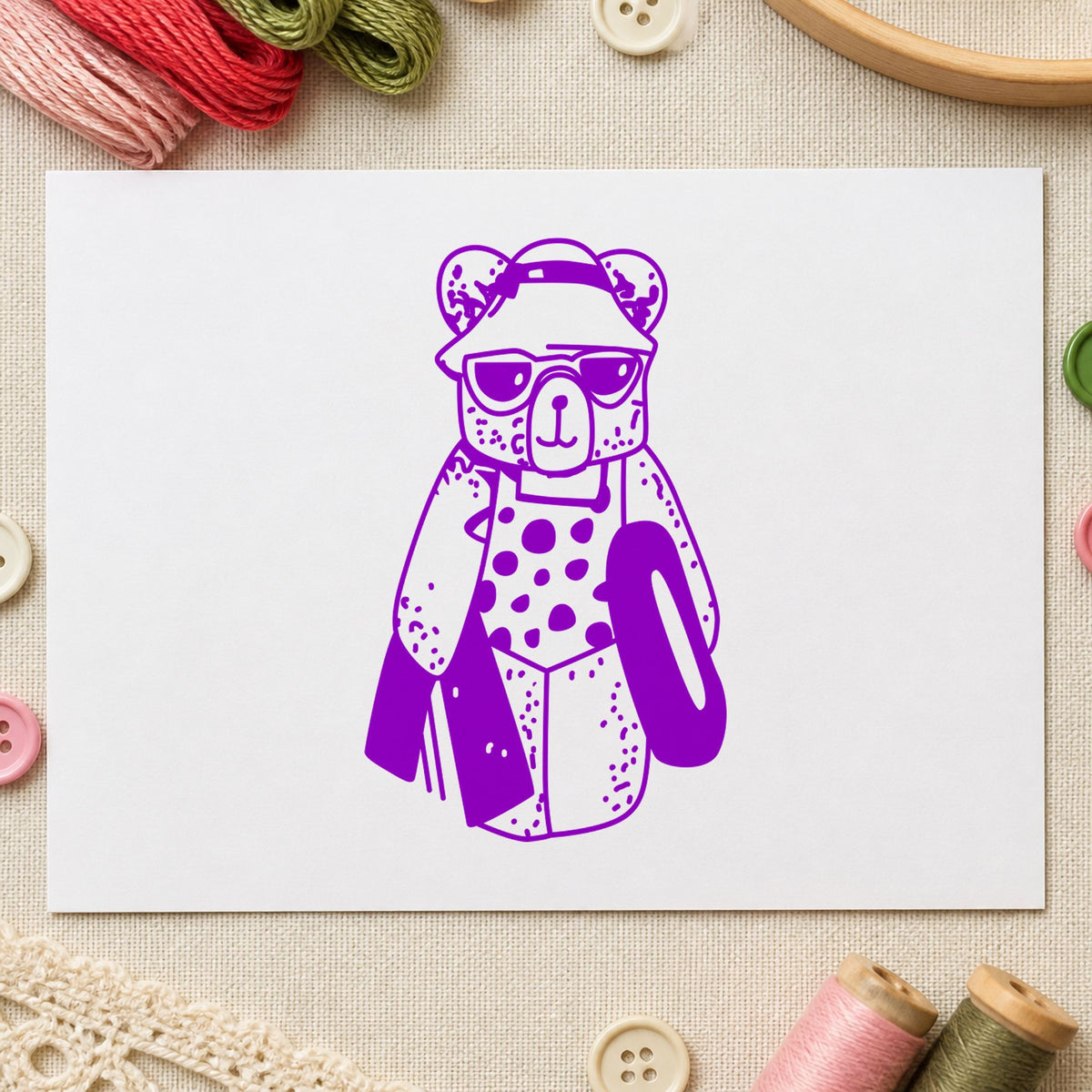 Bear with Inner Tube Rubber Stamp impression in purple ink on white paper in a styled craft setting.