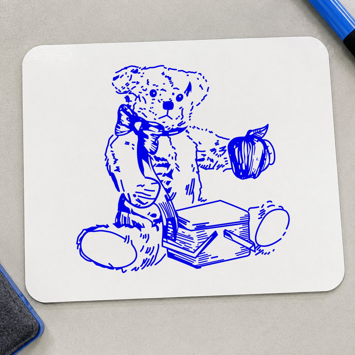 Bear with Picnic Basket and Apple Rubber Stamp impression in blue ink on white paper in a styled craft setting.