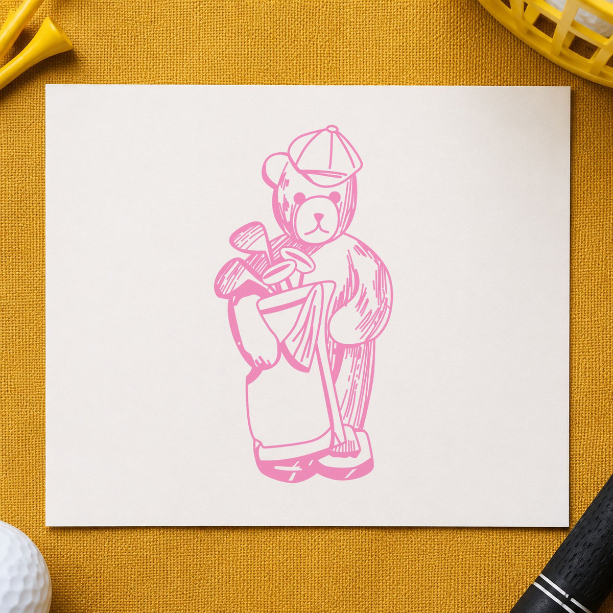 Golf Bear with Clubs Rubber Stamp impression in pink ink on white paper in a styled craft setting.