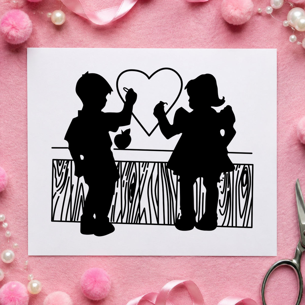 Black impression from a valentine rubber stamp, featuring the boy and girl drawing a heart design on white paper.