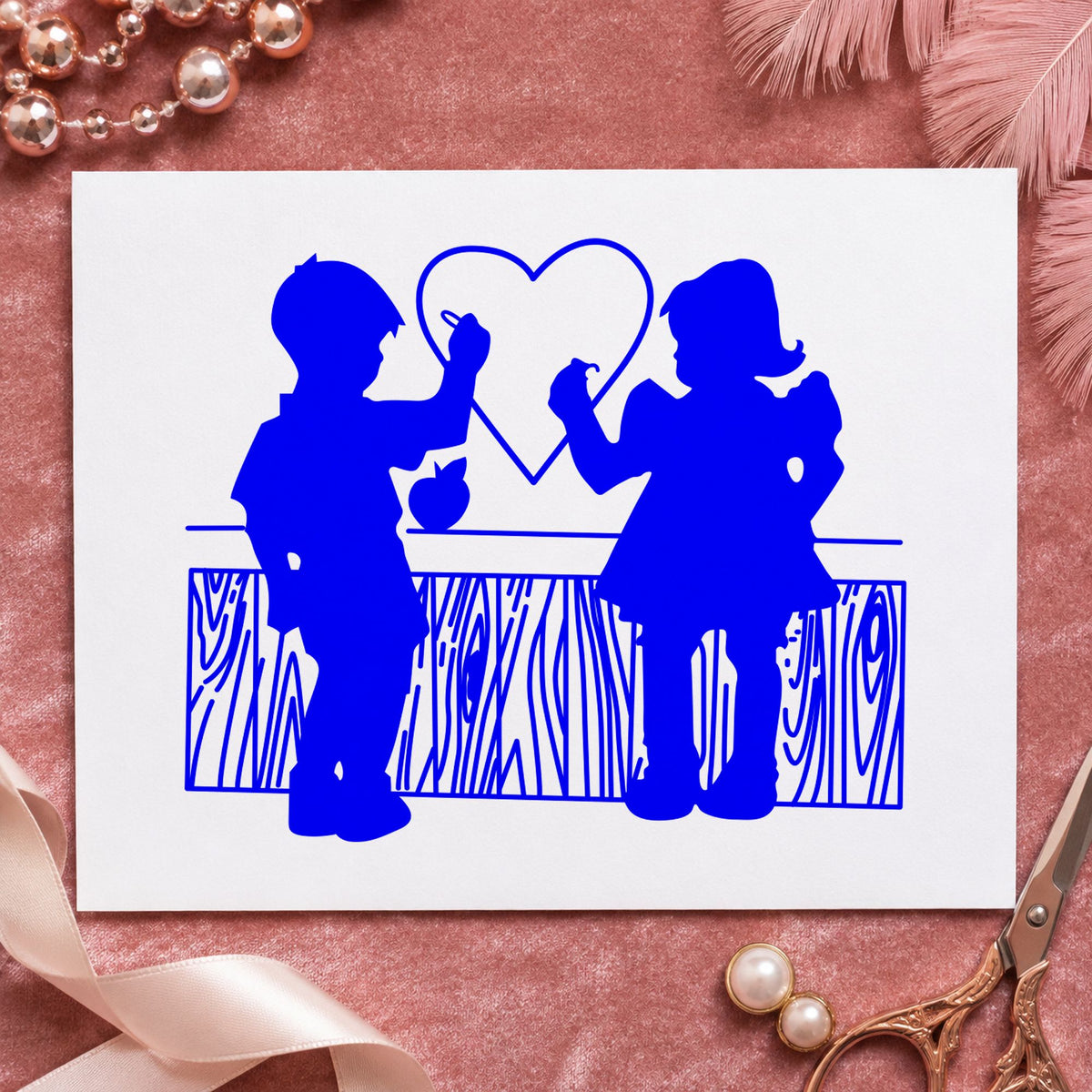 Blue romantic silhouette stamp impression featuring the boy and girl drawing a heart design on white paper.
