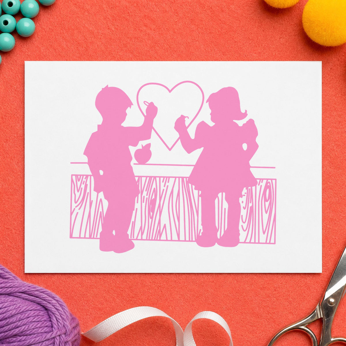 Boy and Girl Drawing a Heart Rubber Stamp impression in pink ink on white paper in a styled craft setting.