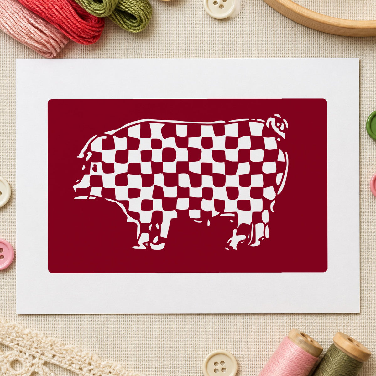 Checkered Pig Block Rubber Stamp impression in burgundy ink on white paper in a styled craft setting.