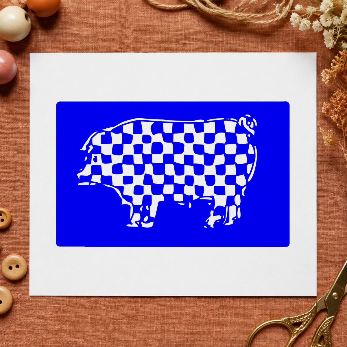 Blue checkered pattern stamp impression featuring the checkered pig block design on white paper.
