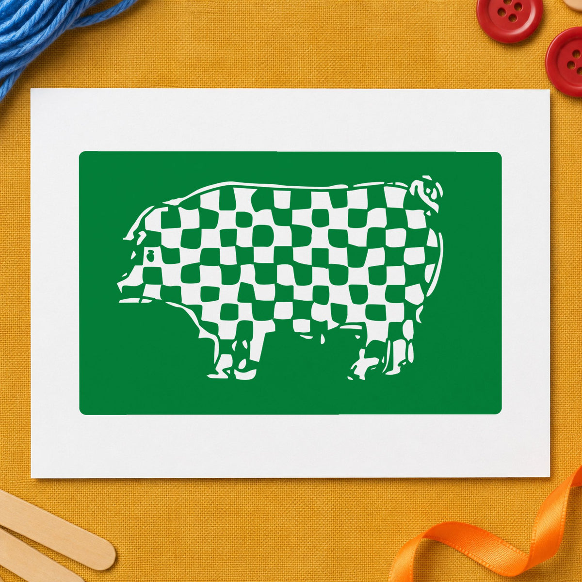 Checkered Pig Block Rubber Stamp impression in green ink on white paper in a styled craft setting.