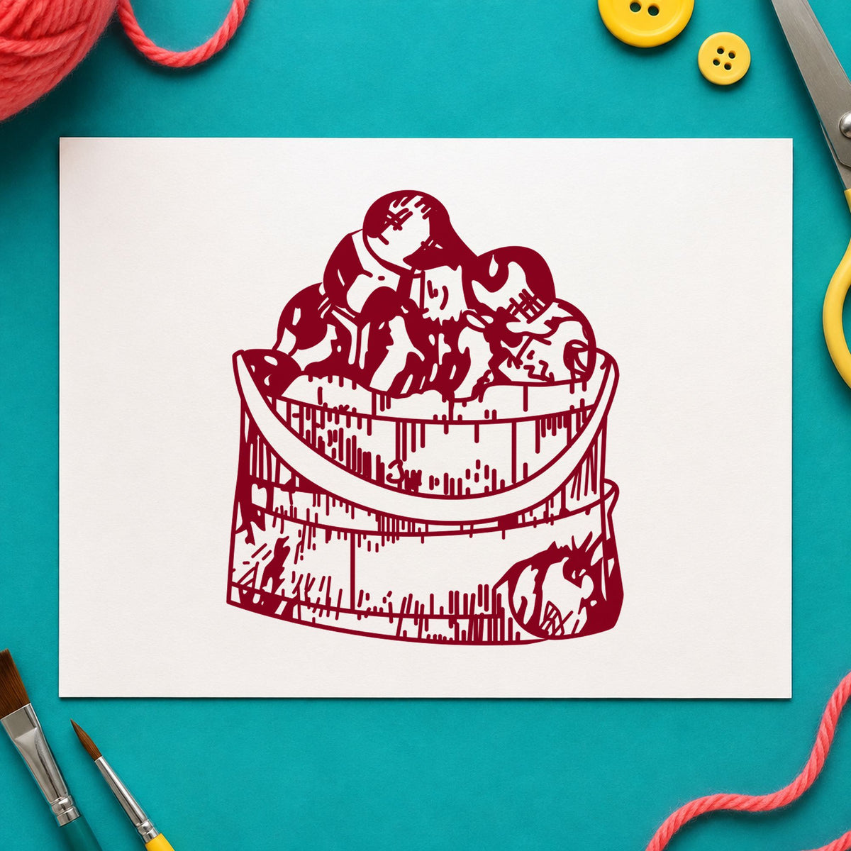 Wooden Bucket of Apples Rubber Stamp impression in burgundy ink on white paper in a styled craft setting.